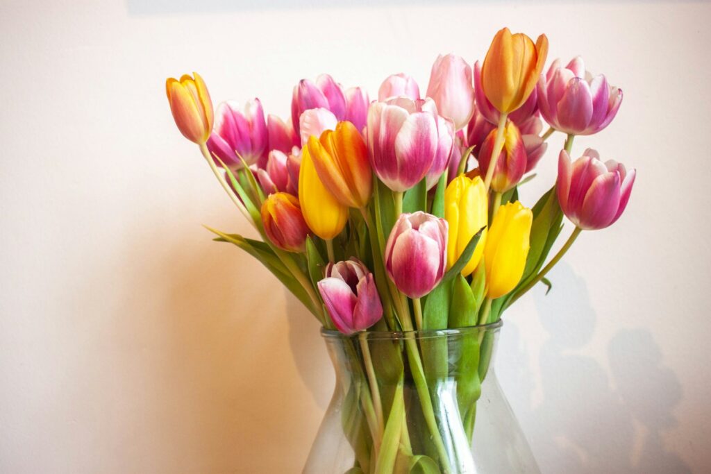 a vase filled with lots of colorful tulips